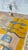 One-of-a-kind handwoven Moroccan Boujaad rug — warm mustard and dove grey, crossed by a chain of navy and slate-blue...