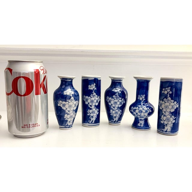 A delightful collection of five miniature blue‑and‑white porcelain vases, each standing 4 inches tall and featuring...