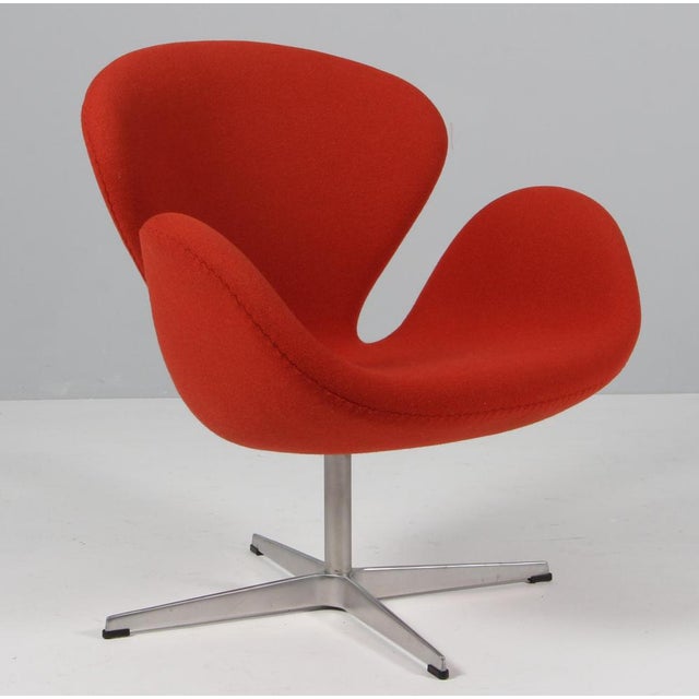 The swan chair, original upholstered with deep orange/red wool fabric Made by Fritz Hansen. This iconic chair is one of...