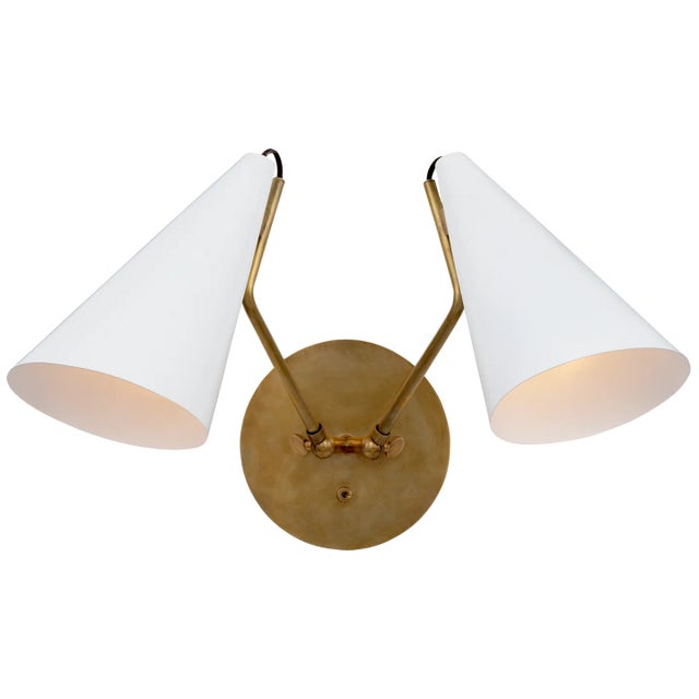 Clemente Double Sconce in Hand-Rubbed Antique Brass with Matte White Shades Designer: AERIN Height: 10.75" Extension:...