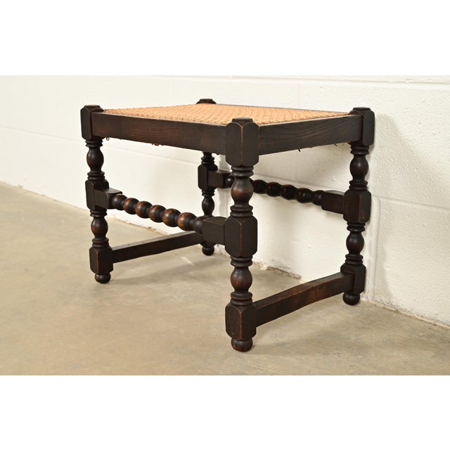 A beautiful antique English Jacobean or Tudor style stool or ottoman In the manner of Berkey & Gay USA, Circa 1920s Turned...
