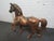 This unusual horse sculpture is adorned with ornate pieces of metal and copper coins.