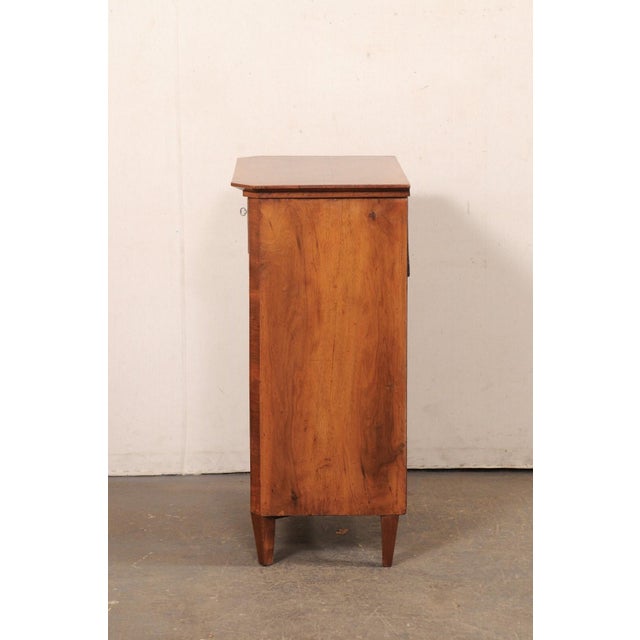 A five-drawer wood Italian side chest from the early 19th century. This antique chest from Italy features a slightly...