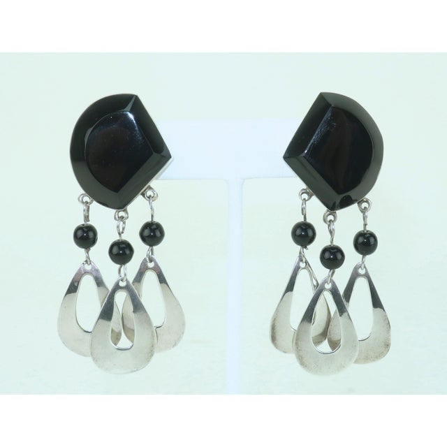 1960’s Mexican sterling silver clip-on earrings featuring tear drop shaped drop dangles and black glass embellishment....