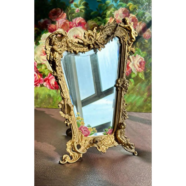 Beautiful antique Italian Rococo-style table mirror with gilded (probably brass) frame, featuring putti (cherubs) decor...