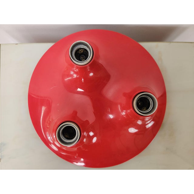Red Triteti wall lamp designed by Vico Magistretti for Artemide in the 1970s. It shows normal signs of wear due to age and...