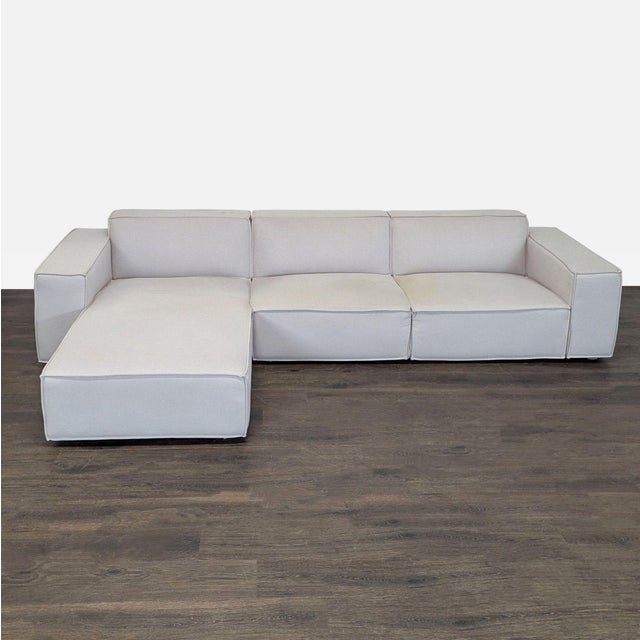 This Rove Concepts sectional features a clean, modern design in light neutral fabric. It includes a spacious chaise lounge...