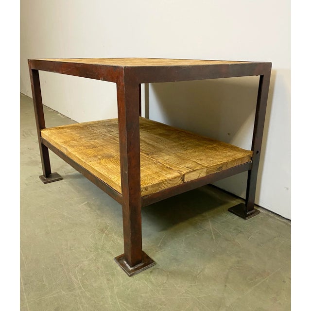 Vintage industrial coffee table from the 1960s. Made of wood and iron. It features a red iron construction and two solid...