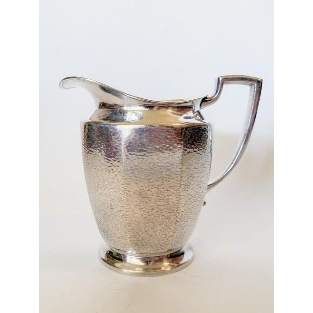 Lovely hammered silver pitcher, perfect for water or iced tea. It has a great shaped handle with a flared end and a large...