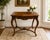 This refined French Louis XV style walnut table, likely from the 19th or early 20th century, showcases the graceful curves...