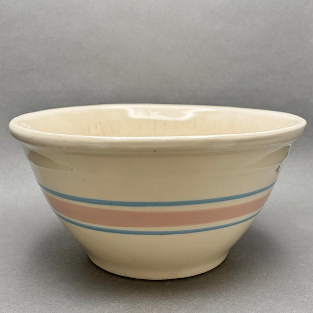 • McCoy Pottery large mixing bowl with classic pink and blue banded design. • Made in the USA, circa 1970s. • Cream glazed...