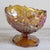 A stunning example of vintage American pressed glass, featuring brilliant amber tones, intricate geometric detailing, and...