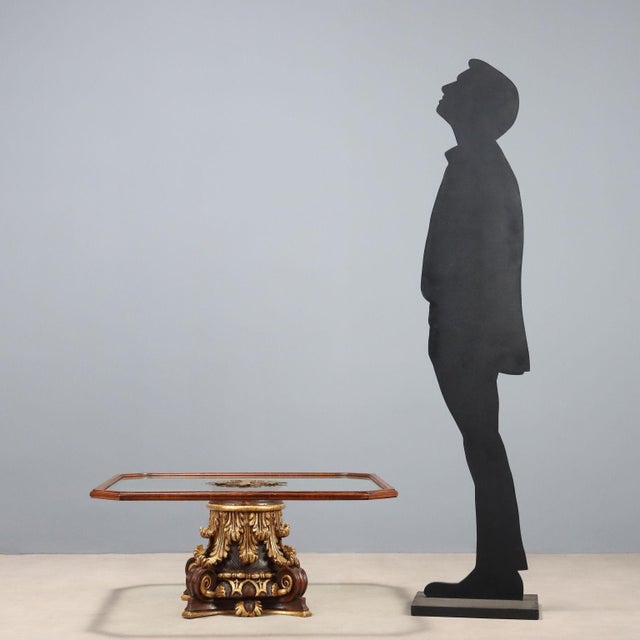 Coffee table. Glass top with wooden frame. Base consisting of a carved, lacquered, and gilded Corinthian capital. Italy,...