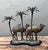 This enchanting vintage sculpture captures a serene desert scene, featuring a pair of meticulously detailed camels...
