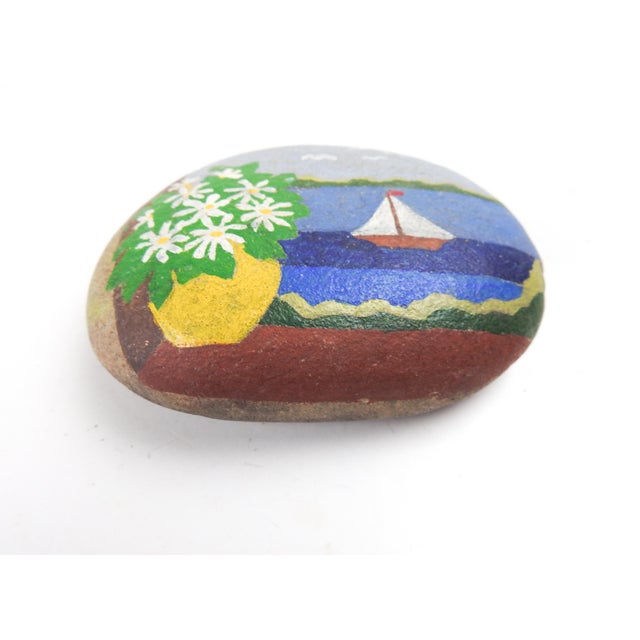 Vintage 1970's handpainted rock paperweight. Coastal window scene with sailboat and daisies, minor surface wear.