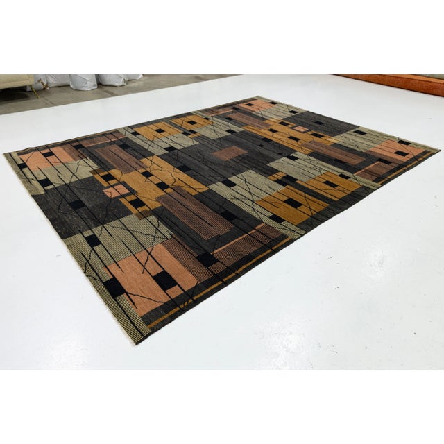 This hand-woven Turkish rug features a modern style made from wool. The rug boasts a brown, goldenrod, and gray Art Deco...