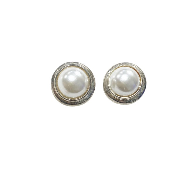 This elegant pair of earrings features a vintage design with a large faux pearl round shape at its center , white gold...