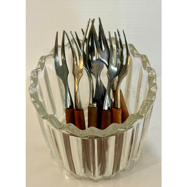 A stylish set of nine vintage Japanese cocktail/appetizer forks featuring polished stainless steel heads and warm wooden...