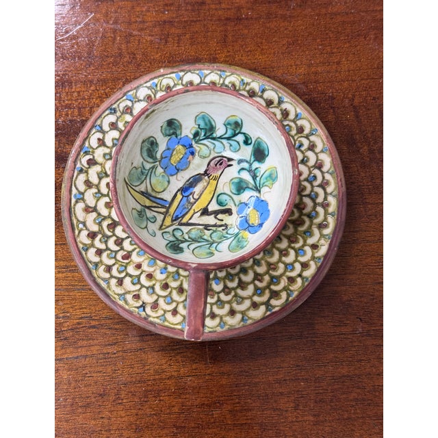 Design Plus Gallery presents an Italian Hand Painted Teacup on Saucer. The teacup is mounted on a round saucer base,...