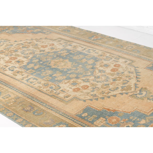 This is a vintage Turkish Oushak rug from the Mid 20th Century. The piece was hand-knotted.