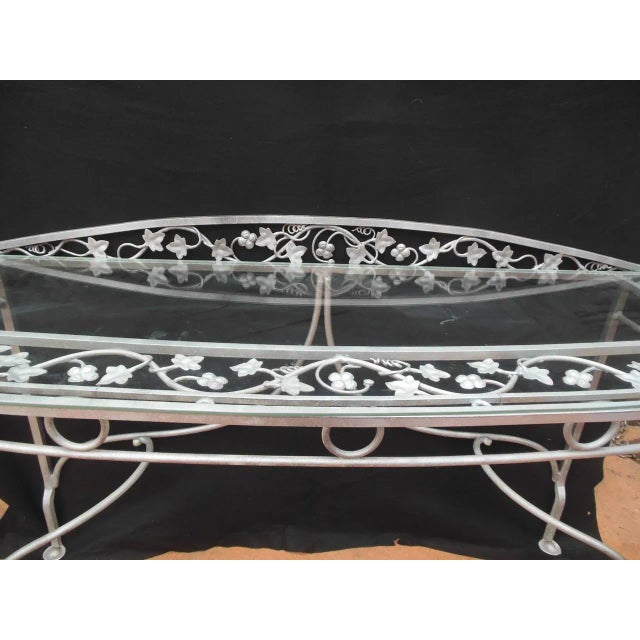 Important vintage wrought iron and glass console table in the style of John Salterini. This exact table is shown in an...