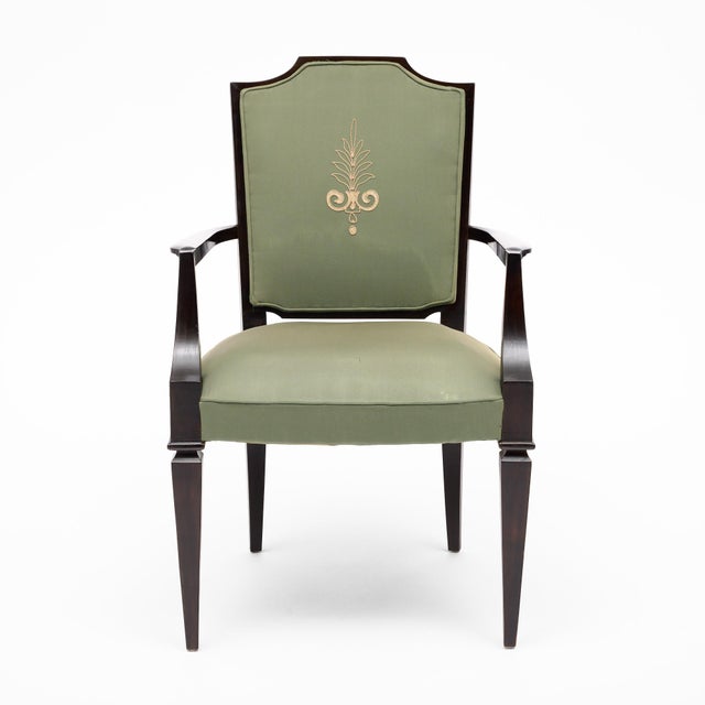 A handsome set of four armchairs in the French Art Deco tradition, constructed in dark ebonized wood and upholstered in a...