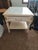 This vintage French Provincial style cream-painted end table features an inlaid marble top insert and a single drawer.