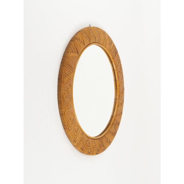 Midcentury beautiful round wall mirror in rattan and wicker in the style of Vivai Del Sud. Made in Italy in the 1970s. V