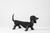 Edouard Shenck. Pair of zoomorphic wrought-iron andirons with a black patina, shaped like dachshunds. Made in France in...