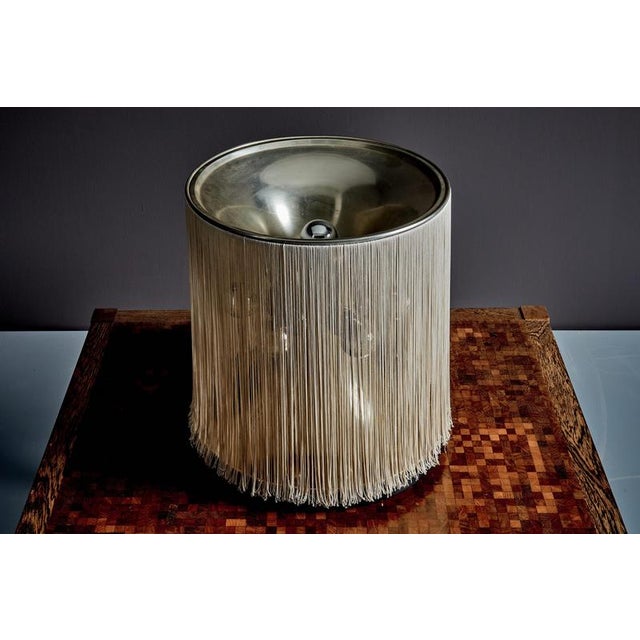 Table lamp designed by Gianfranco Frattini in 1961 and produced by Arteluce. Cylindrical structure covered with a dense...