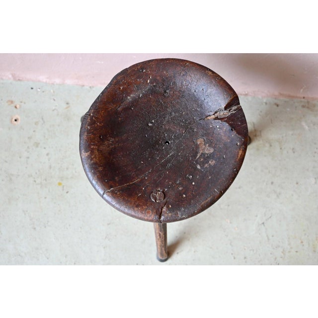 Here's a stool that has lived, and tells its story with disarming candor! This tripod stool in solid wood, with its...