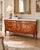 A substantial French Louis XV-style triple commode featuring a beautifully shaped serpentine front, warm figured wood, and...