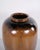 Large floor vase made in ceramic with a brown glaze. The vase has a simple design and large size, making it suitable as a...