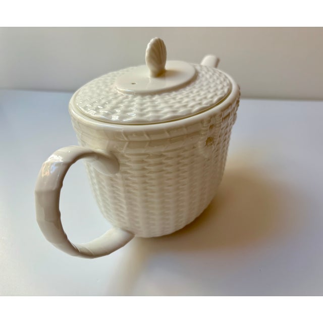 This is a Wedgwood Nantucket series teapot in fine bone china. It features an embossed basketweave pattern design and a...