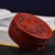 This circular red lacquer box features magnificent raised relief carving of a phoenix surrounded by floral details on the...