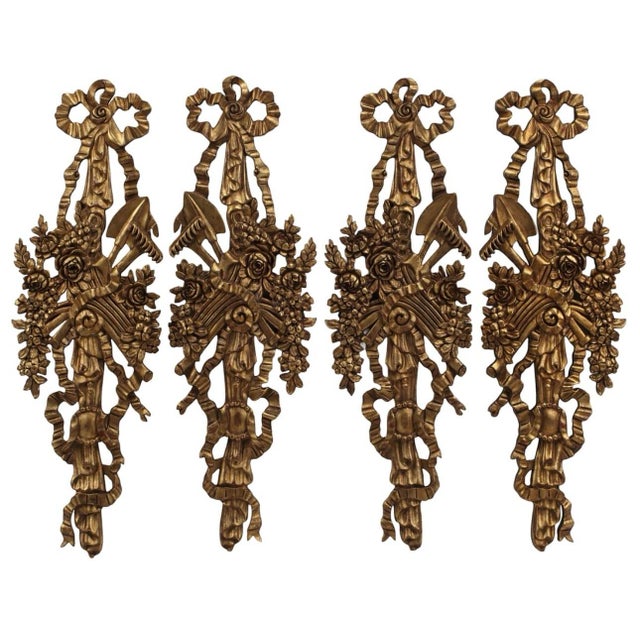 Stunning large pair of French carved gilt wood wall trophies/ plaques. Made of solid wood with carved bow swag above...