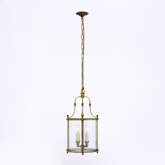 Lantern from France in the Louis XVI style. This piece has a brass structure with finely cast details. Four candelabra...