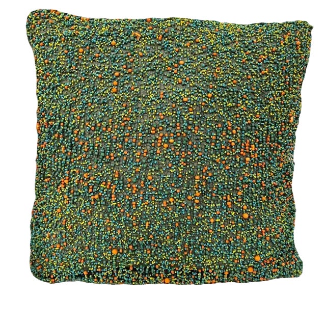 Hundreds of colorful beads sewn with black wire thread make this decorative pillow unique.