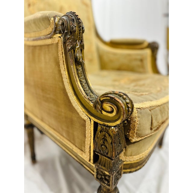 An elegant and generously scaled French Louis XVI style bergère chair featuring beautifully detailed carved wood framing...