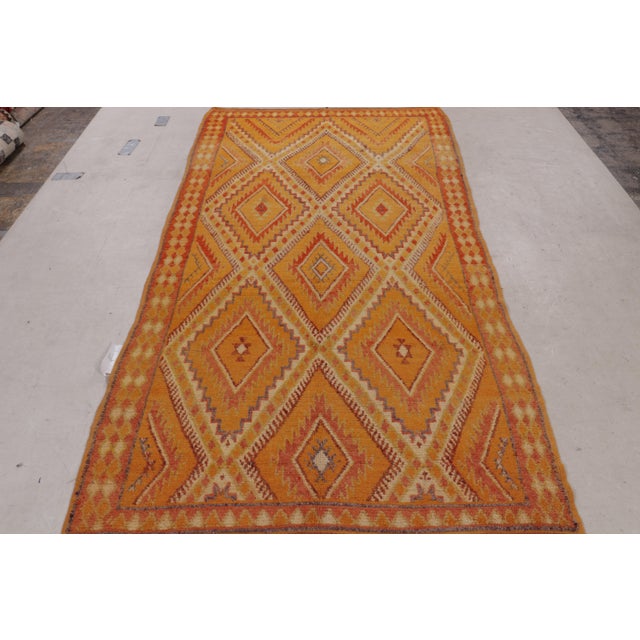 Hand knotted in wool originating from Morocco circa 1950-1960, this vintage mid-century Moroccan rug hails from the Berber...