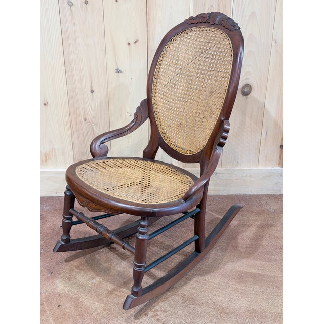 A beautifully detailed vintage Victorian-style rocking chair crafted in mahogany, combining decorative carving with the...