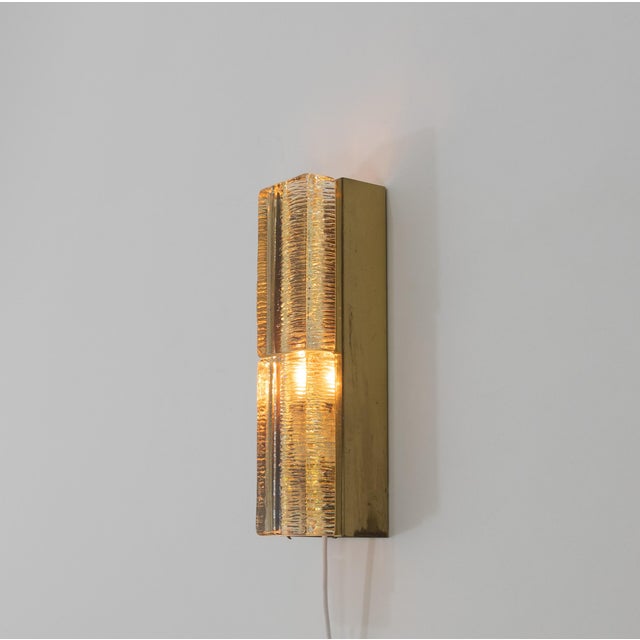 A glass and brass Atlantic wall lamp designed and produced by Danish lighting manufacturer Vitrika in the 1970s. The lamp...