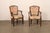 An Italian pair of Neoclassical style carved wood and upholstered armchairs from the mid-20th century. These mid-century...