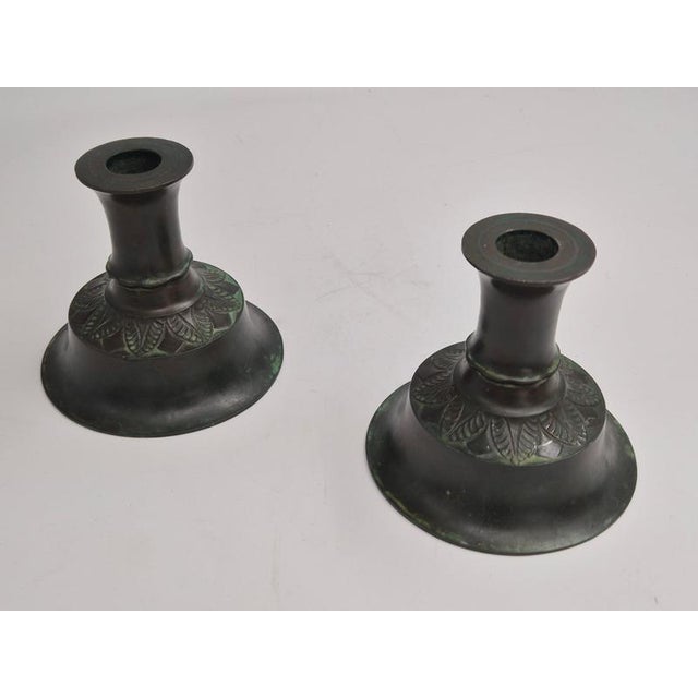 A decorative and rare pair of candle holders by just andersen, danish grace 1920/30s. Beautiful decor of pedals. The pair...