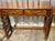 This elegant wooden console table features a rich oak grain finish, two utility drawers and distinctively carved turned...