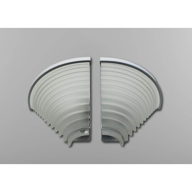 Pair of Egisto corner wall lamps, manufactured by Artemide, designed by Angelo Mangiarotti. The lamps have a white...