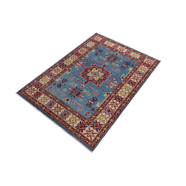 Enhance your home with this exquisite hand-knotted Kazak rug, crafted from fine hand-spun wool and dyed with all-natural...