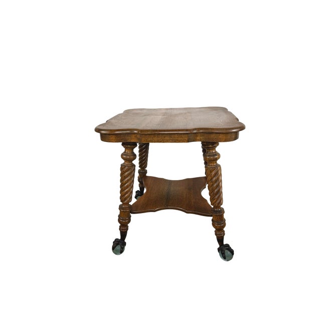 A striking early 20th century tiger oak parlor table distinguished by richly figured grain, sculptural barley-twist legs,...
