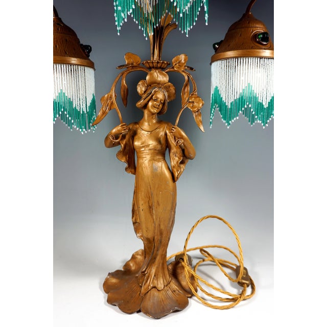 Tall table lamp with a young woman decorated with flowers, 'Flora' - goddess of blooming, as a base, stylized branch-like...