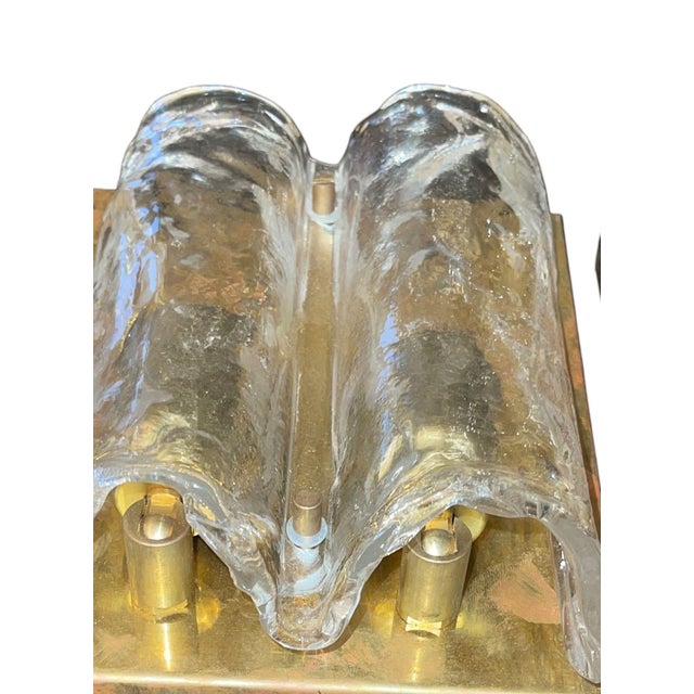 Stylish pair of Italian mid-century Murano glass wall sconces, circa 1970's, each designed with a rectangular brass...